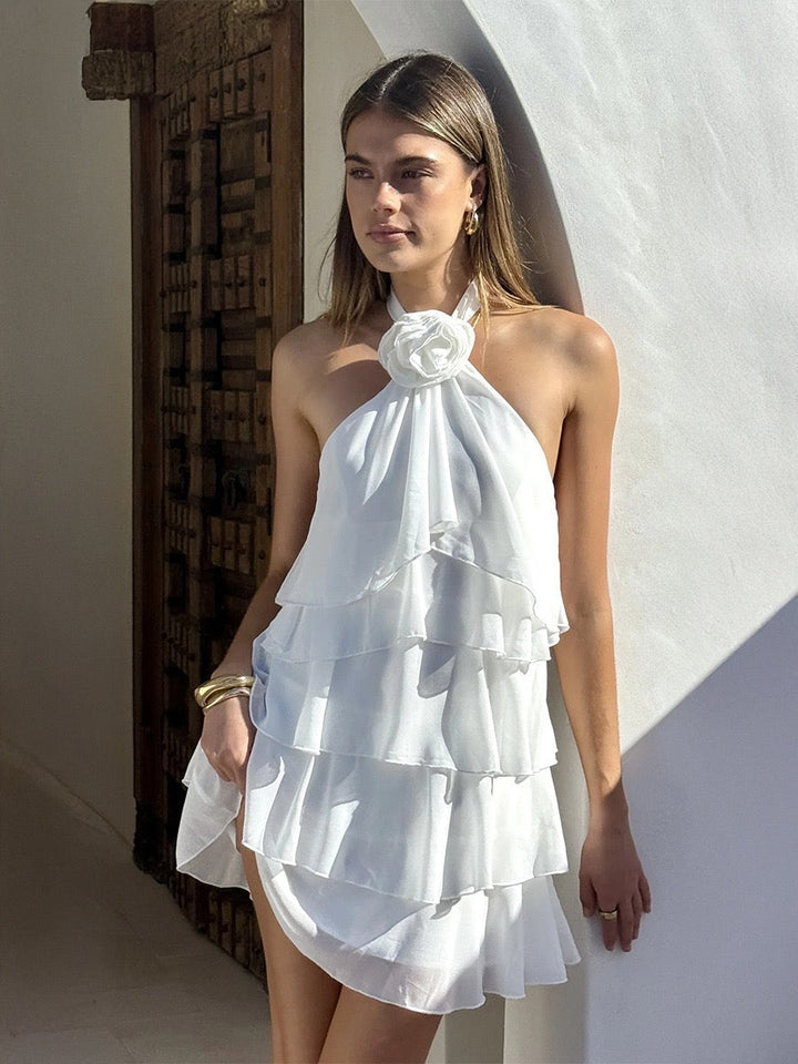 Lily tiered chiffon ruffle mini dress with a neck tie, open back, and floral trim