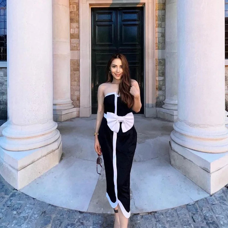 One-piece strapless swimsuit in a luxurious asymmetrical design with bow tie decoration combined with a matching skirt in monochrome colors - Gabriella