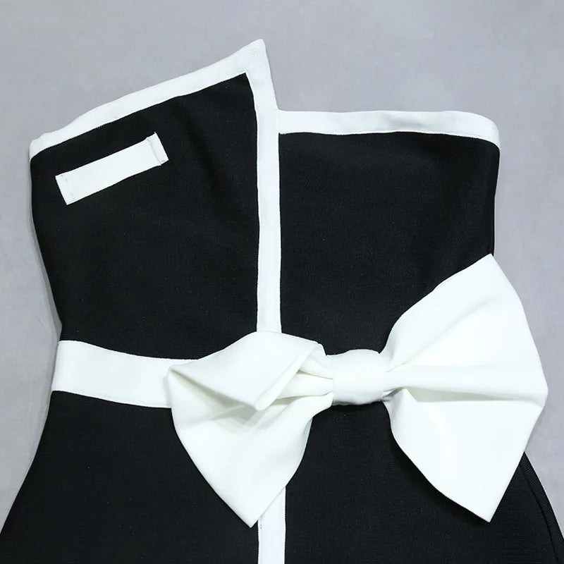 One-piece strapless swimsuit in a luxurious asymmetrical design with bow tie decoration combined with a matching skirt in monochrome colors - Gabriella
