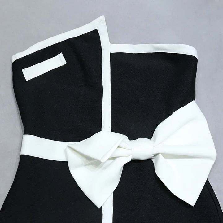 One-piece strapless swimsuit in a luxurious asymmetrical design with bow tie decoration combined with a matching skirt in monochrome colors - Gabriella