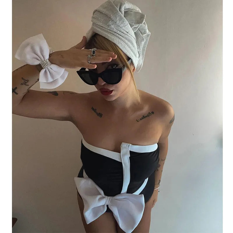 One-piece strapless swimsuit in a luxurious asymmetrical design with bow tie decoration combined with a matching skirt in monochrome colors - Gabriella
